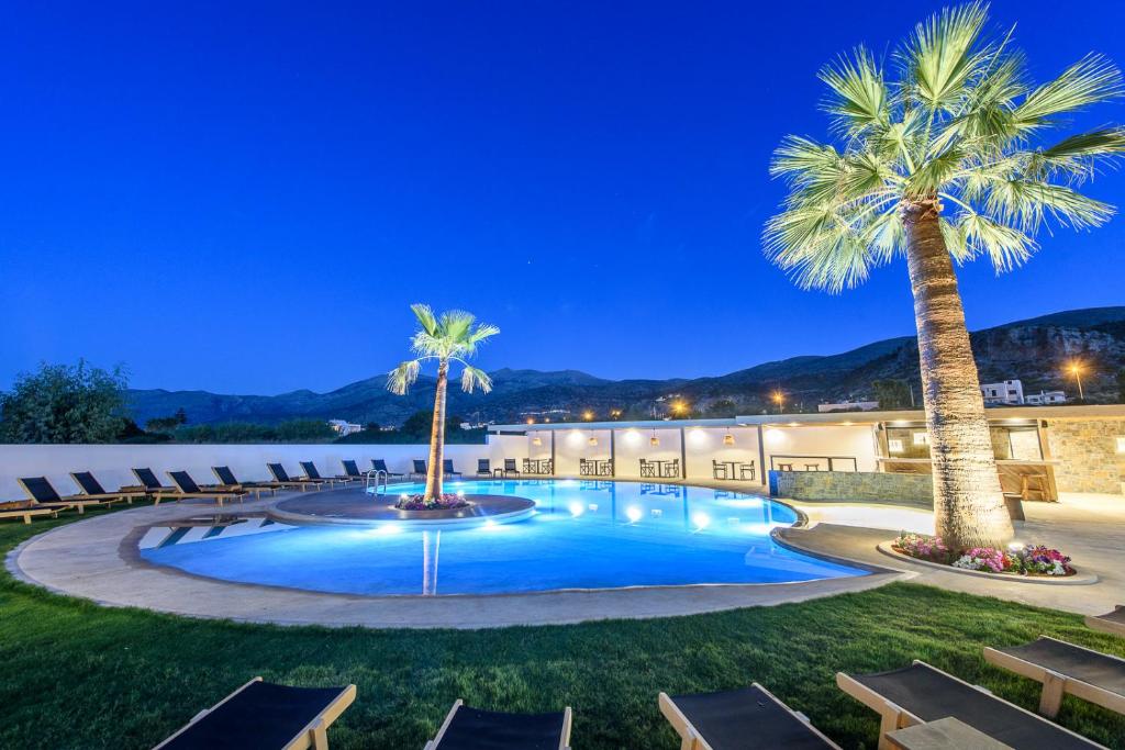 uma piscina de resort com palmeiras e espreguiçadeiras em AneSea Hotel em Malia