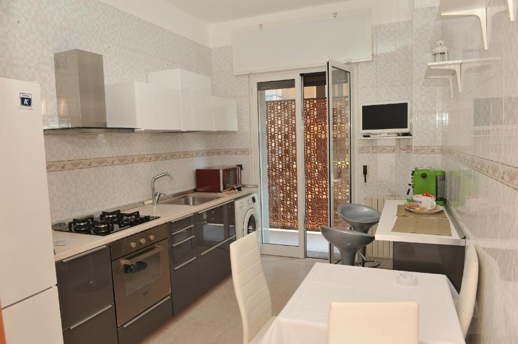 a kitchen with a stove and a sink and a table at Casa Sarahouse in Taranto