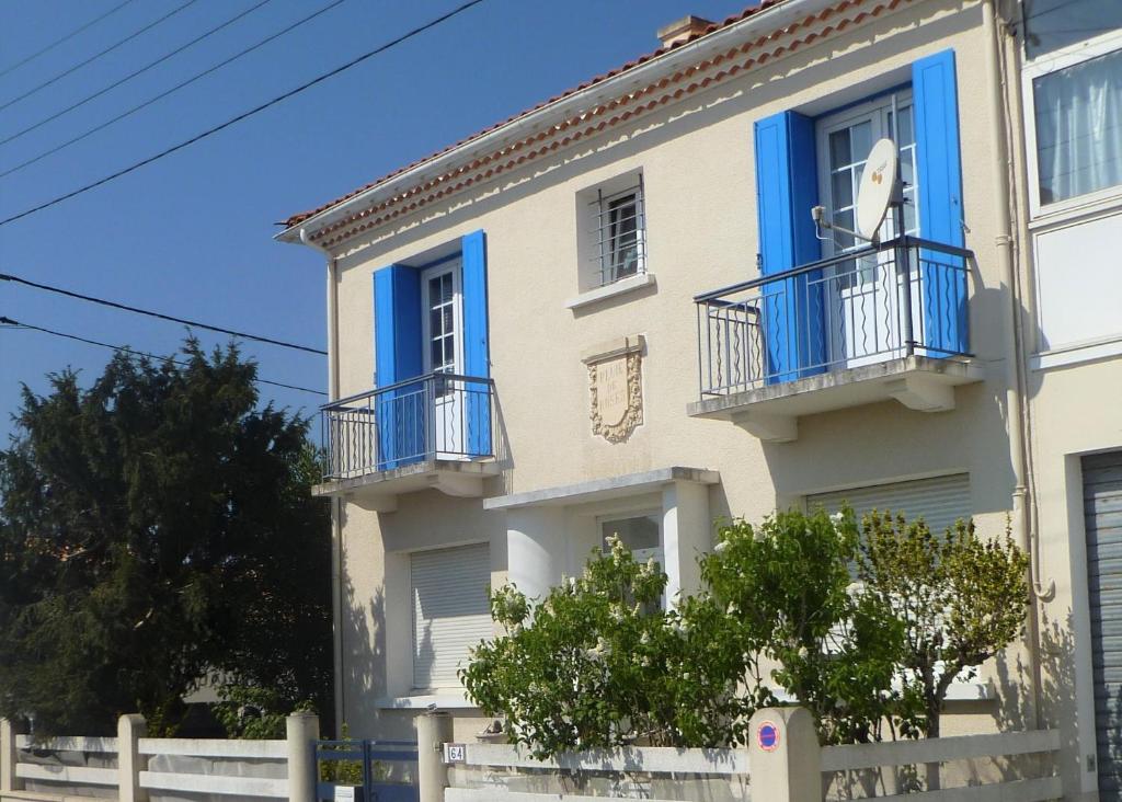 a building with blue windows and balconies on it at Pluie de roses in Royan