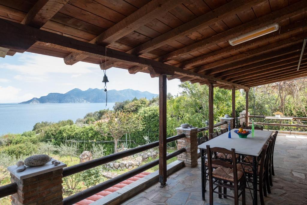a porch with a table and chairs and a view of the water at Villa Eirini with sea view in Dhriópi