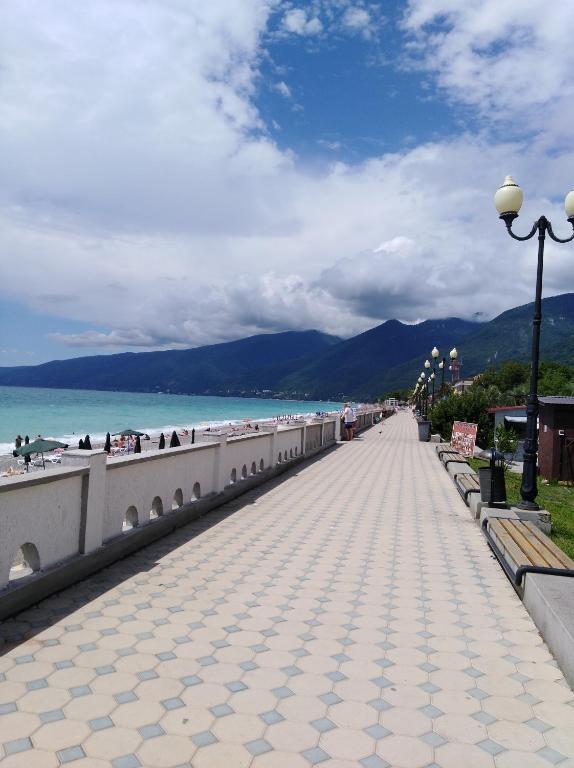 a sidewalk next to the beach with a street light at 2 комнатная квартира in Gagra