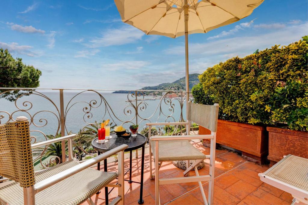 a patio with a table and chairs and an umbrella at Hotel Continental in Santa Margherita Ligure