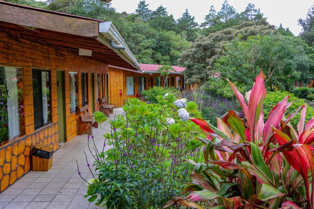ogród z kwiatami i roślinami przed budynkiem w obiekcie El Bosque Trails & Eco-Lodge w mieście Monteverde