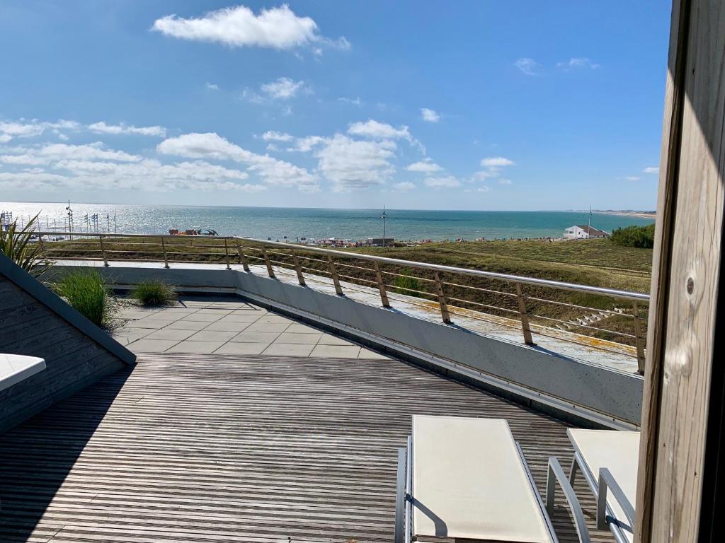 a boardwalk leading to a beach with the ocean at Les Terrasses de l'Océan in Saint-Hilaire-de-Riez