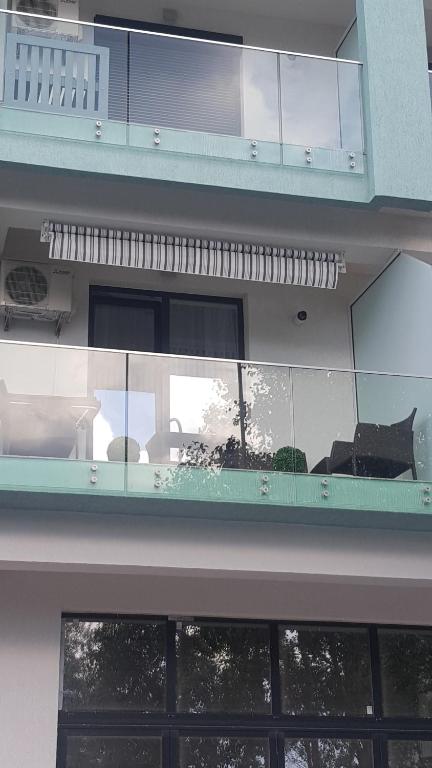 a balcony in a building with a reflection in the windows at Alex Marina flat in Mamaia