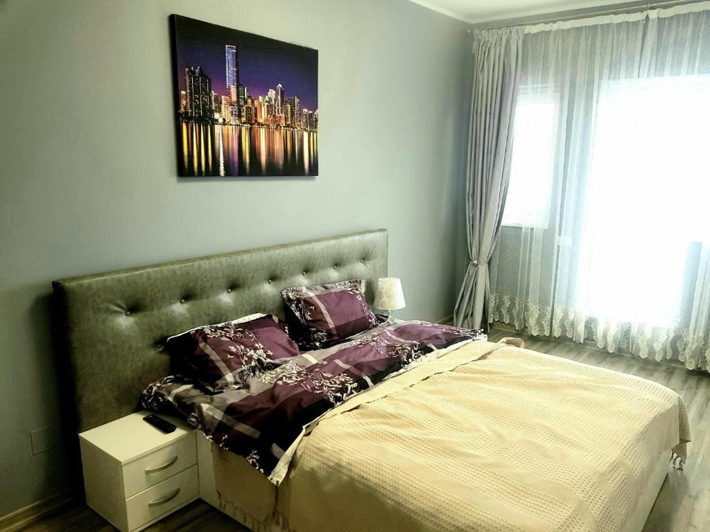 a bedroom with a large bed with purple pillows at Skyline Rooftop Condos in Oradea