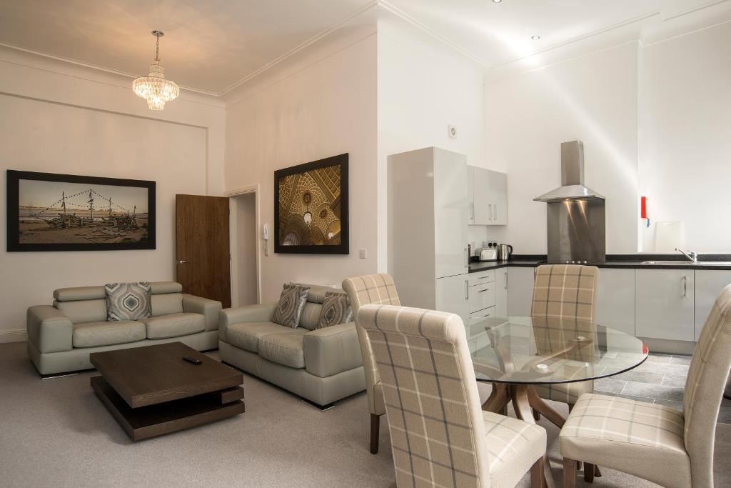 a living room with a table and a kitchen at The Castle Collection 14 Cook Street in Liverpool