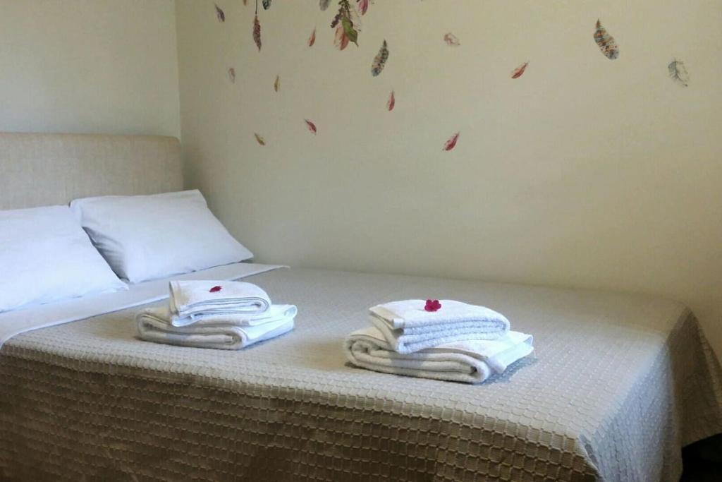 een bed met handdoeken bovenop bij A Cozy Affordable Place at Voula in Athene