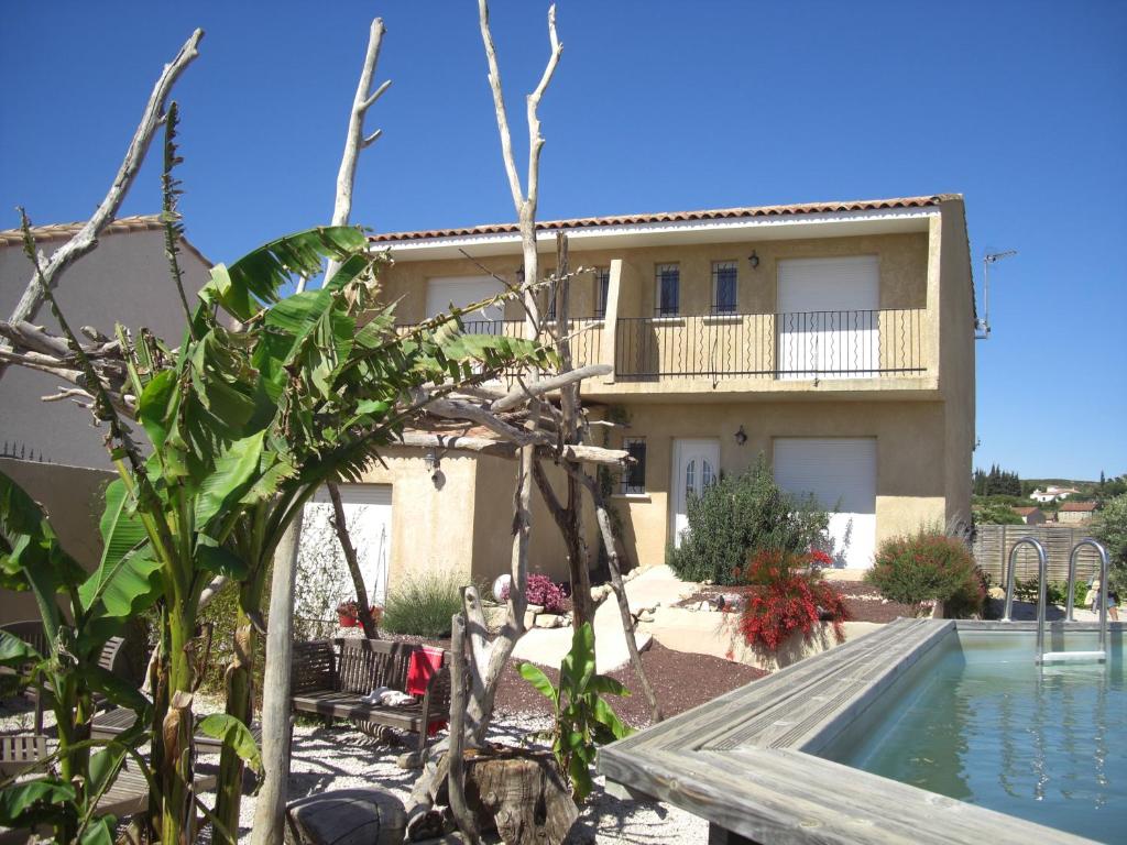 une maison avec une piscine en face de celle-ci dans l'établissement Villa Carignans, à Causses-et-Veyran