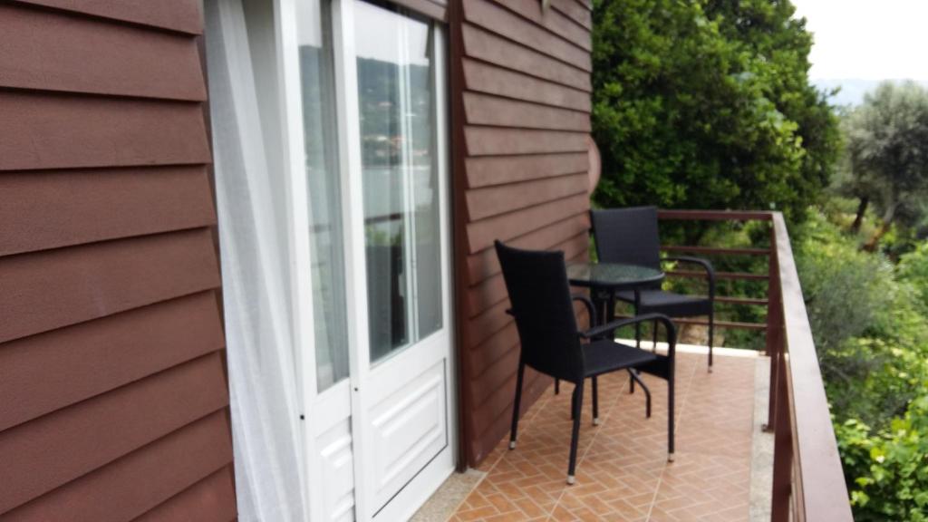 a patio door with chairs and a table on a house at Chalé da Fonte - T2 in Geres
