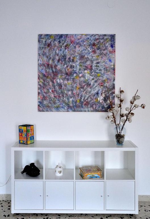 a painting hanging on a wall above a white cabinet at Casa Rosetta in Palermo