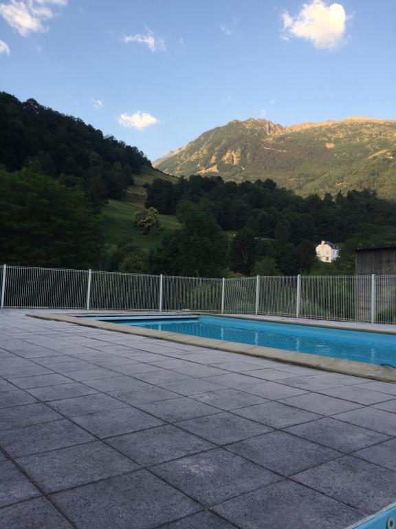 une piscine avec une clôture et des montagnes en arrière-plan dans l&#39;établissement Loc luz st sauveur 2, à Luz-Saint-Sauveur