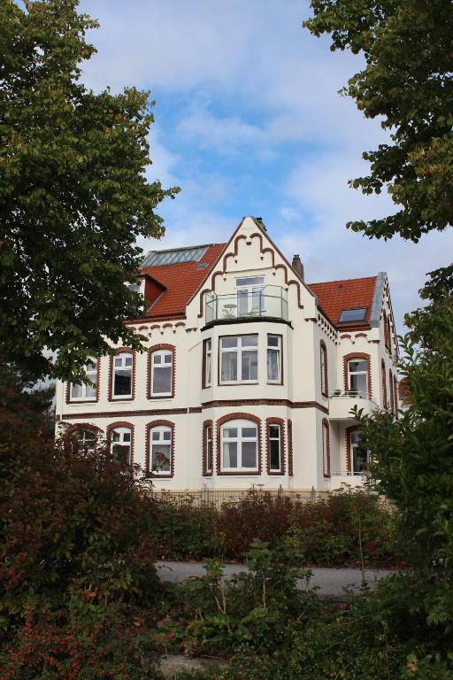 a large white house with a red roof at Ferienwohnungen Schlei 42 in Schleswig