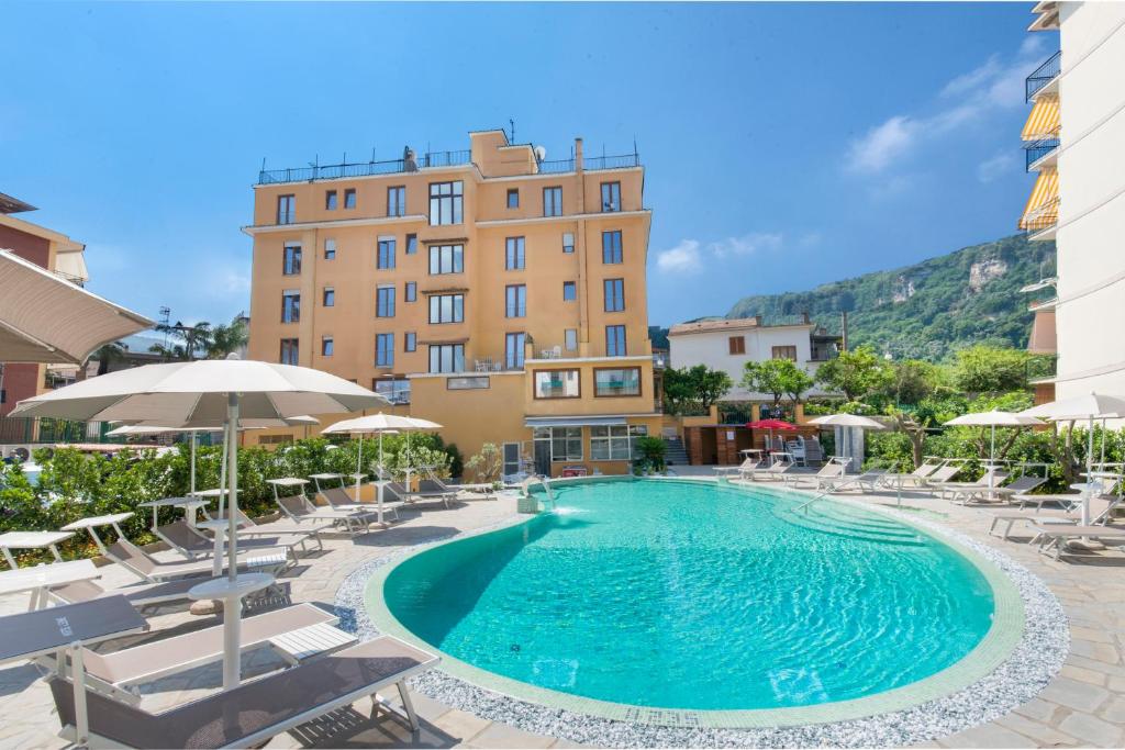 einen Pool in einem Hotel mit Stühlen und Sonnenschirmen in der Unterkunft Hotel Leone in Sorrent