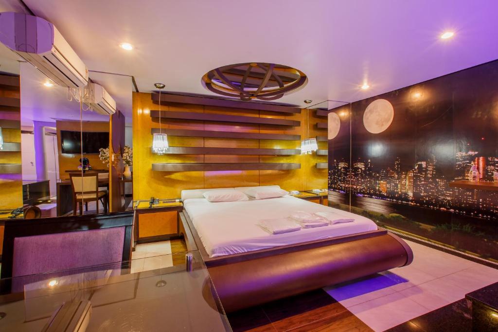 Schlafzimmer mit einem Bett und Stadtblick in der Unterkunft Motel Fascínio (Only Adults) in Cascavel