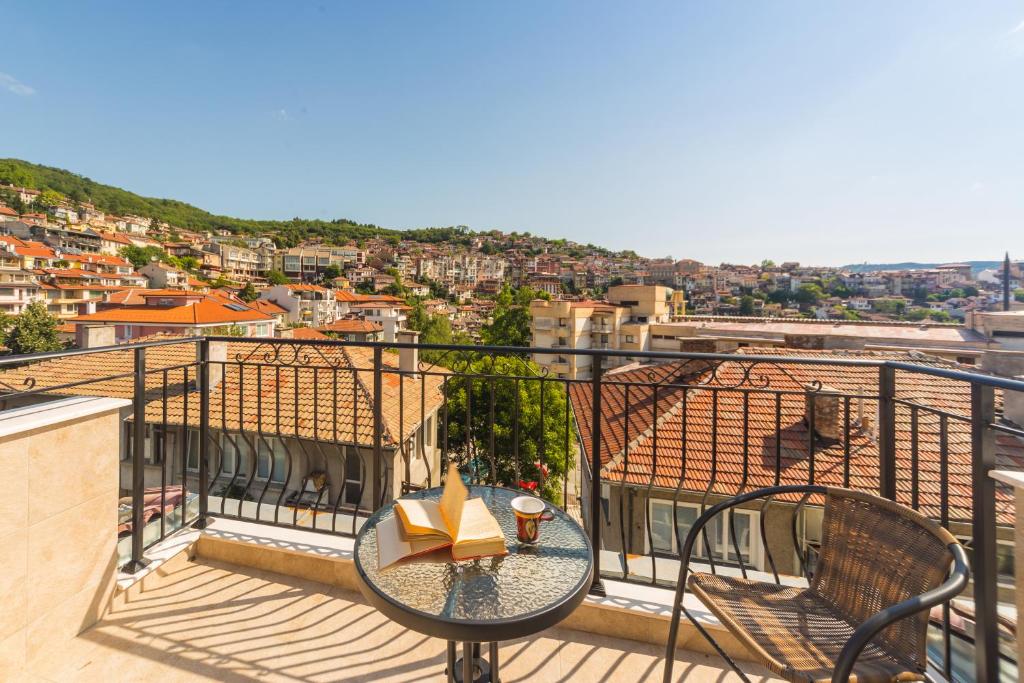 a balcony with a table with a book on it at Kosev Apartment in Veliko Tŭrnovo