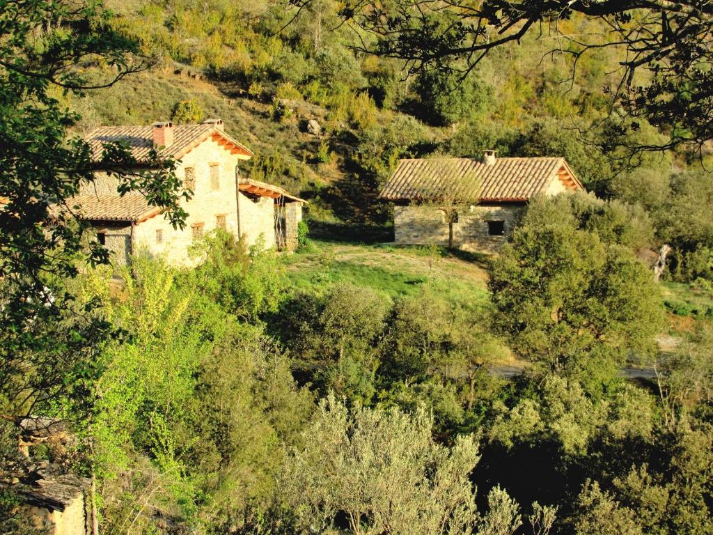 obraz domu na wzgórzu z drzewami w obiekcie Terra del Congost - Alojamientos en la Naturaleza frente al Congost de Mont-Rebei w mieście Castissent