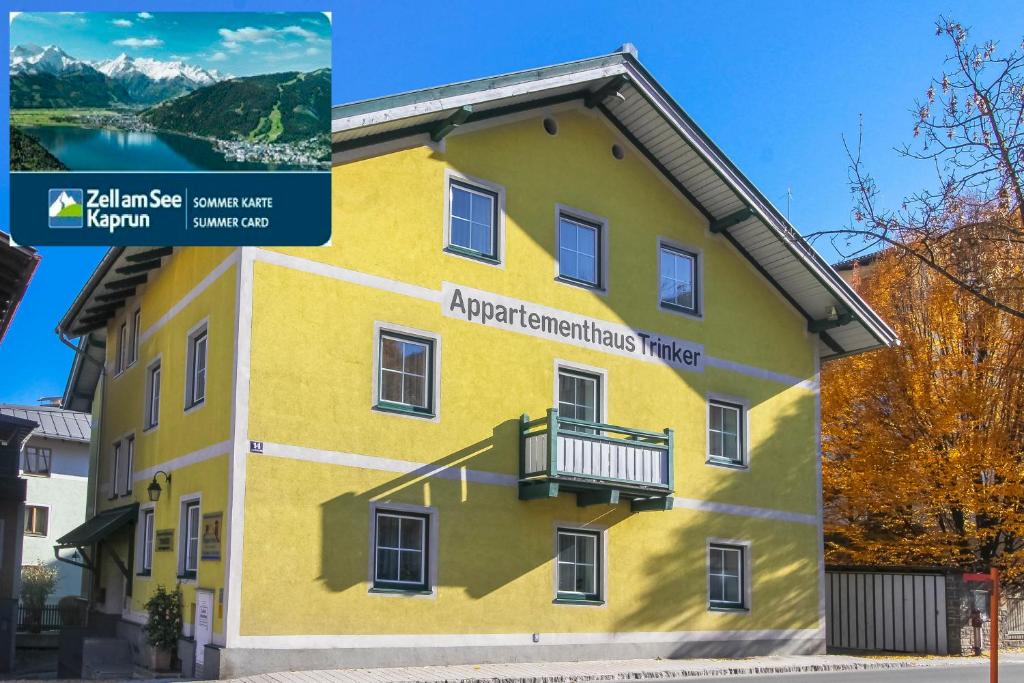 a yellow building with a balcony on the side of it at Appartements Trinker in Zell am See