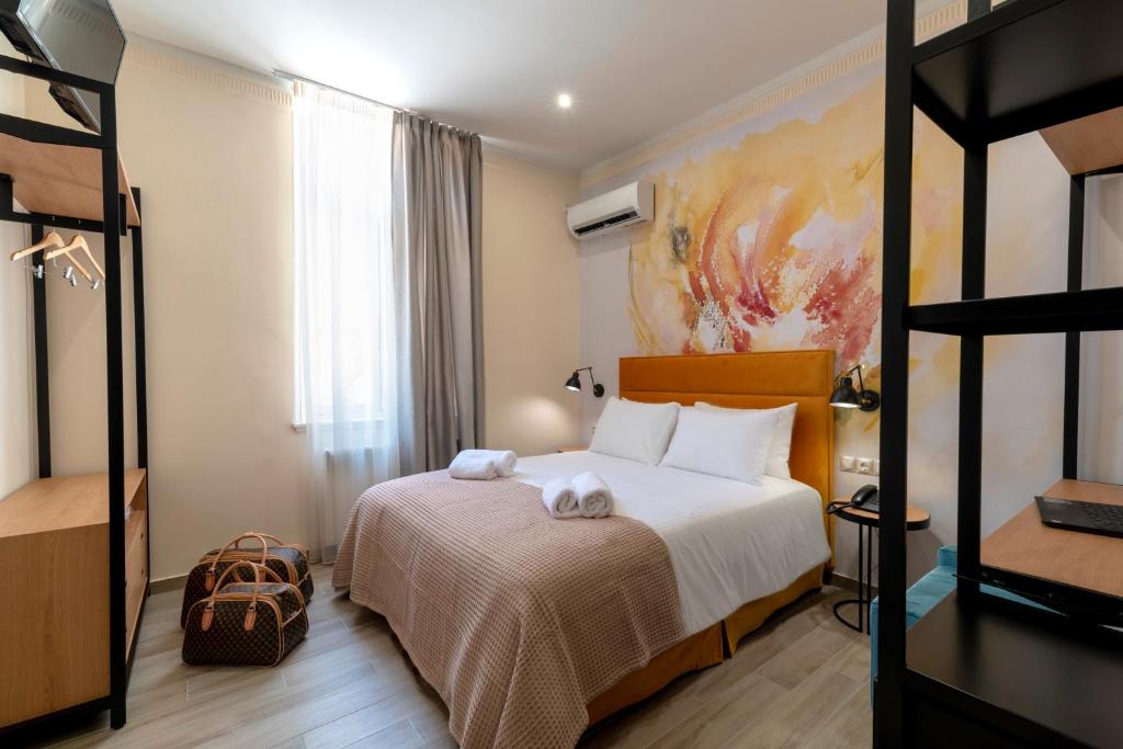 een slaapkamer met een bed met twee handdoeken erop bij Athens Market Portrait in Athene