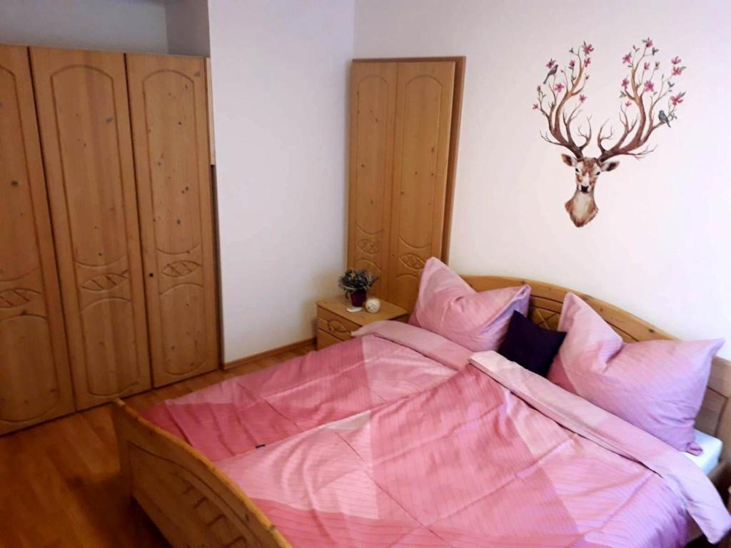 una camera da letto con un letto con una testa di cervo sul muro di Apart Zireiner See a Kramsach