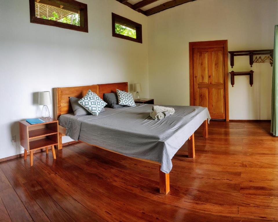 sypialnia z łóżkiem i drewnianą podłogą w obiekcie Ataraxia w mieście Bastimentos