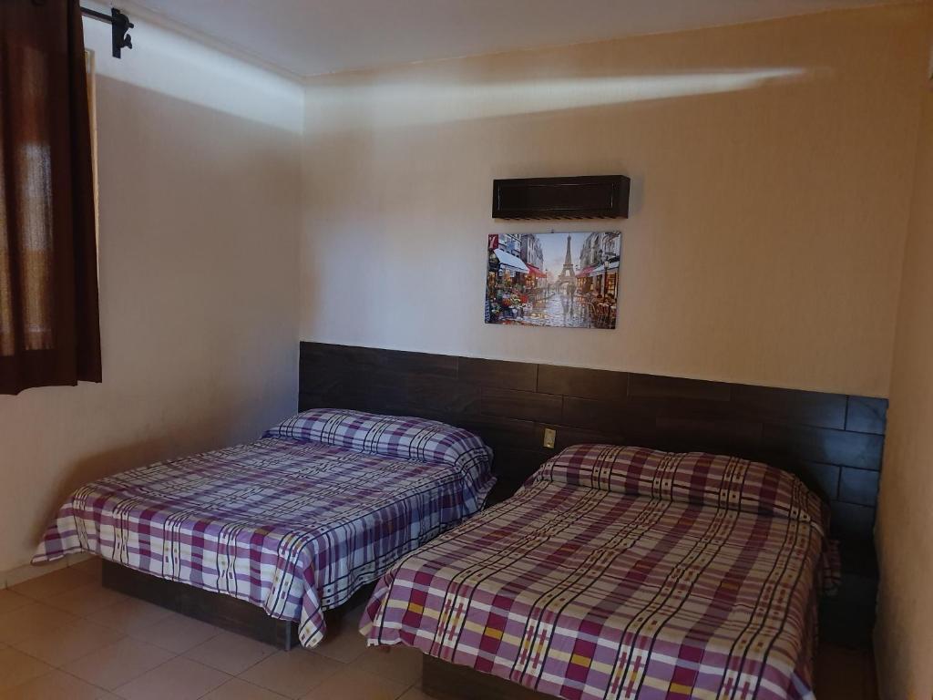 dos camas sentadas una al lado de la otra en una habitación en Costa Miramar en Acapulco