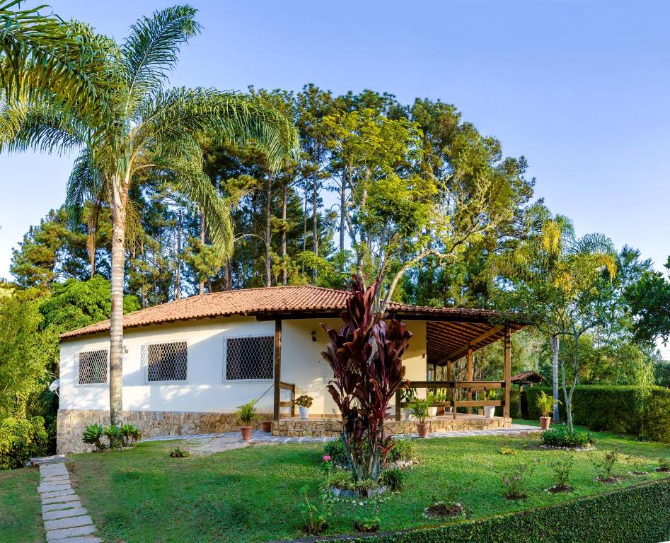 uma casa com uma palmeira no quintal em Refúgio Serrano - Em meio a Mata Atlântica em Petrópolis