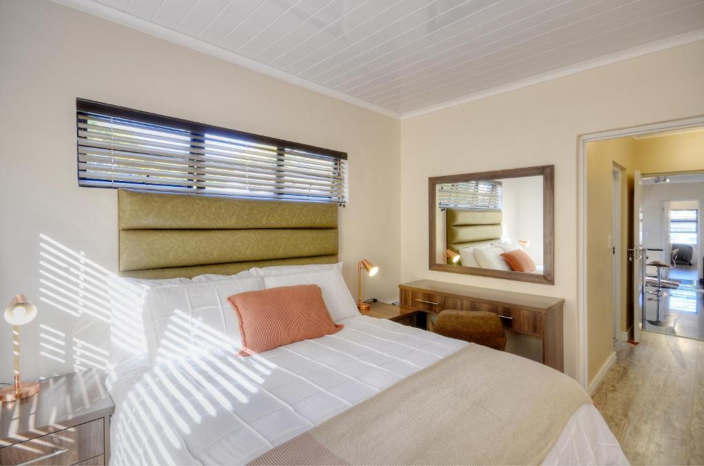 1 dormitorio con cama blanca y ventana en 9a@Crassula Way en Ciudad del Cabo