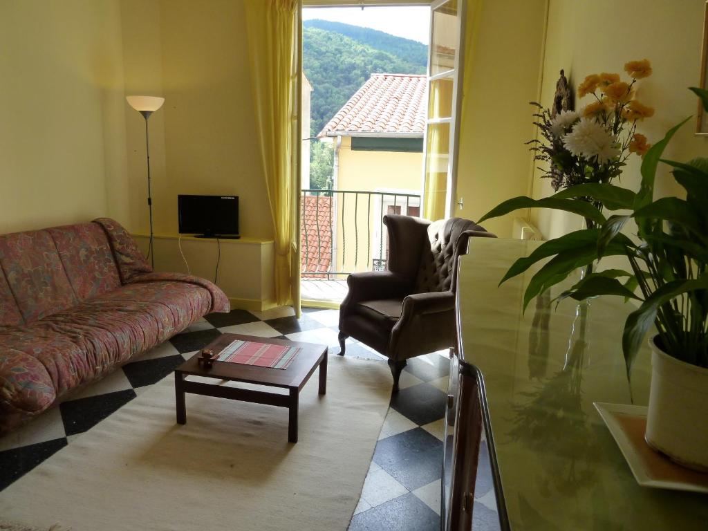 uma sala de estar com um sofá, uma cadeira e uma mesa em Maison Baxter em Prats-de-Mollo-la-Preste