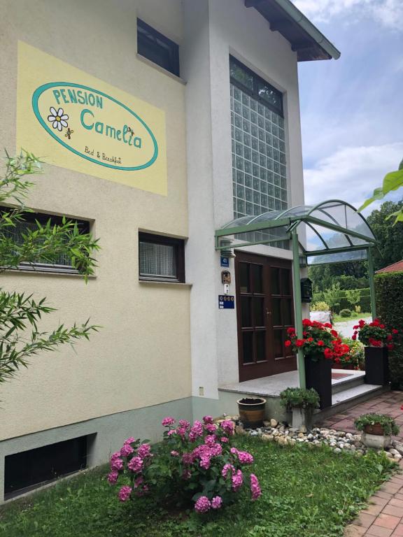 znak na ścianie budynku z kwiatami w obiekcie Haus Camelia w mieście Bad Tatzmannsdorf