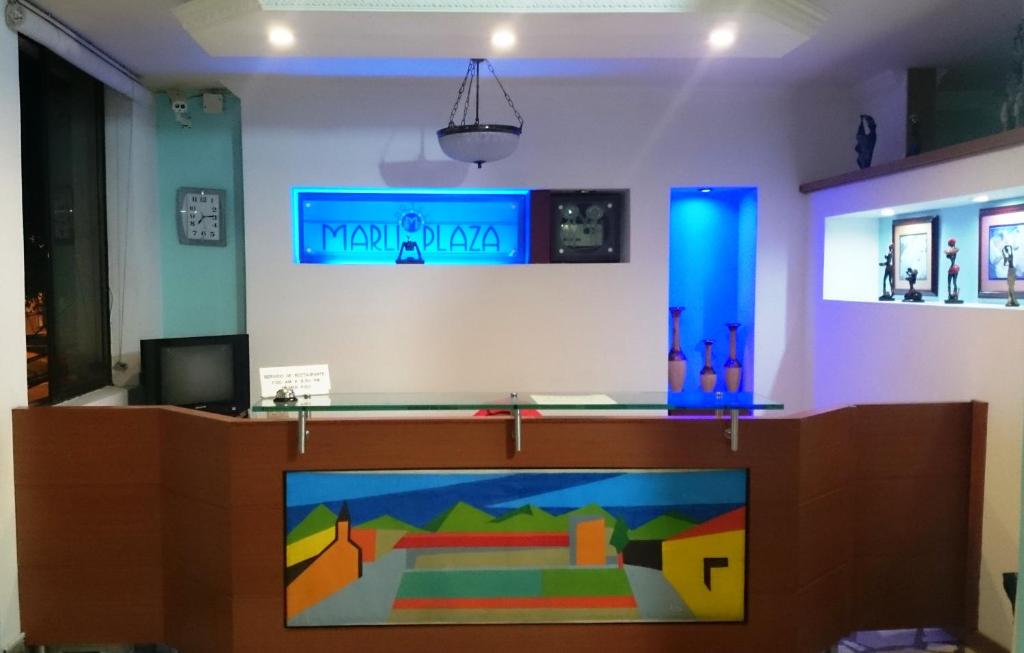 Hotel Marli Plaza في Mocoa: غرفة مع تلفزيون مع لوحة على الحائط