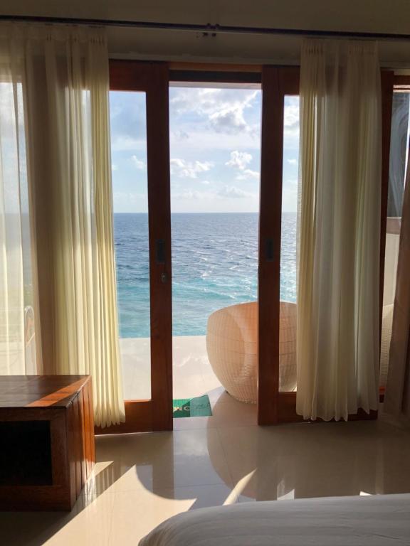 sypialnia z widokiem na ocean w obiekcie Ogix Cliff Paradise w mieście Nusa Penida