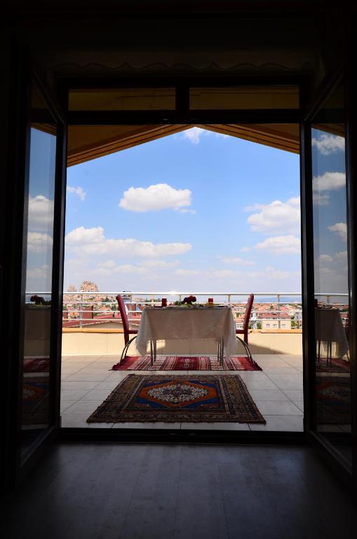 a table and chairs on a balcony with a view of the ocean at Castle Panorama House in Nevsehir