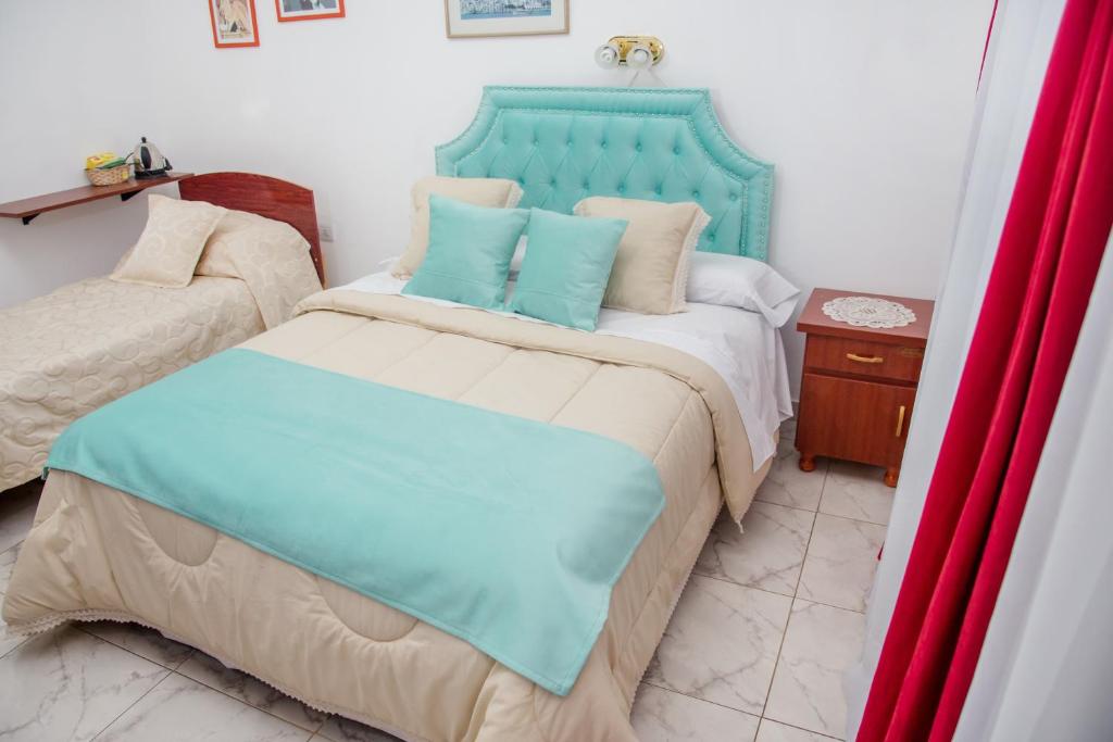 1 dormitorio con 1 cama con cabecero azul en Desayuno en Tiffany's en Arroyo Seco