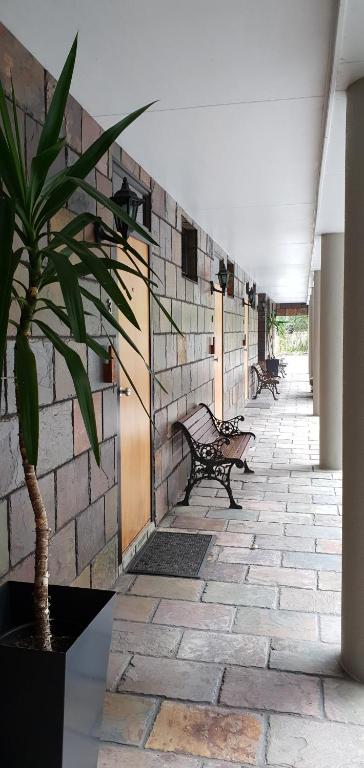 a hallway with benches and a plant in a building at Fitzherbert Castle Motel in Palmerston North