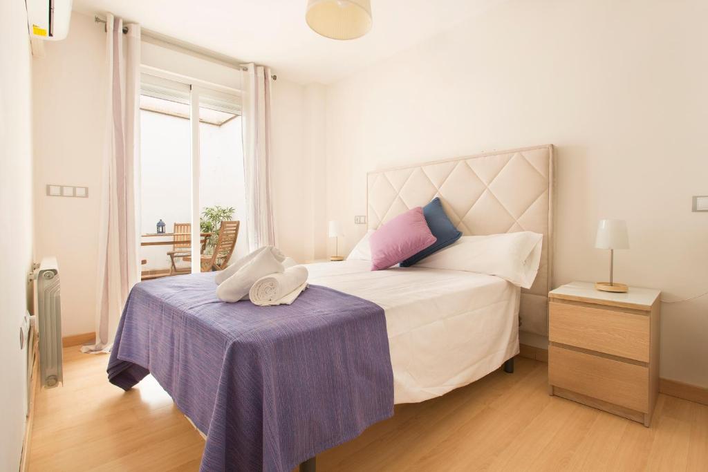1 dormitorio con 1 cama blanca grande y mesa morada en Apartamento Calle Concepcion Centro, en Granada