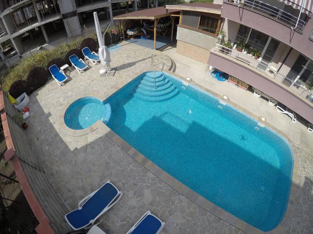 an overhead view of a large blue swimming pool on a building at Anfid Apartments in Burgas