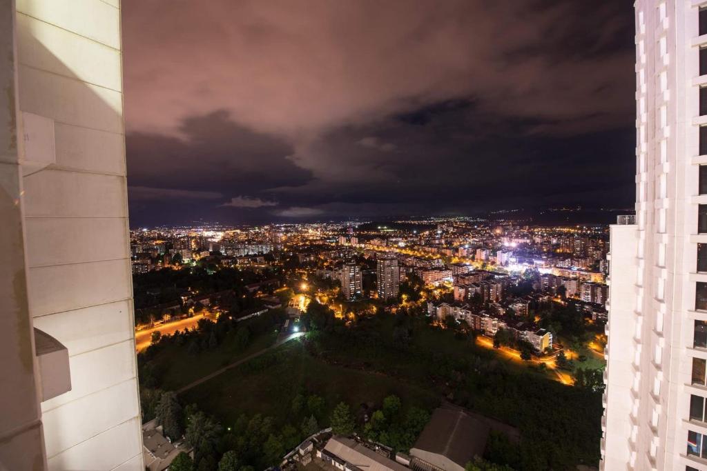 Blick auf die Stadt in der Nacht von einem Gebäude in der Unterkunft 33rd floor luxury apartment spa & fitness in Skopje