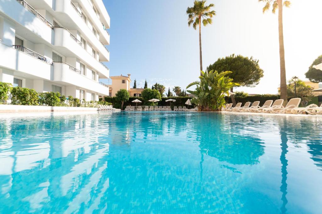 a swimming pool in front of a building at Tropicana Hotel in Cala Millor