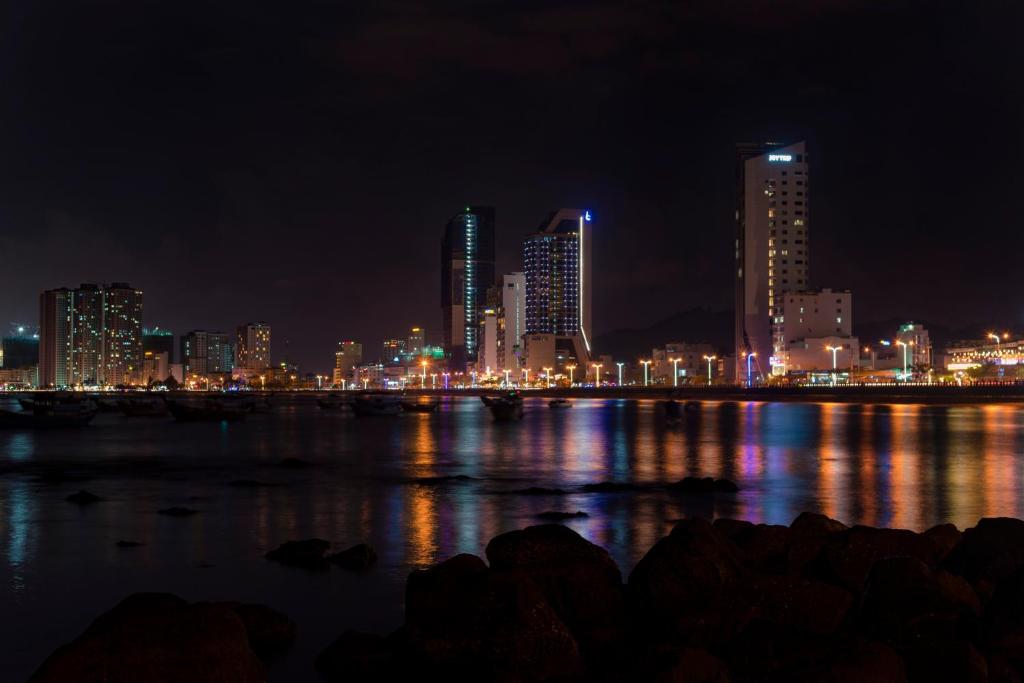 a city skyline at night with the water at Boton Blue Hotel & Spa in Nha Trang