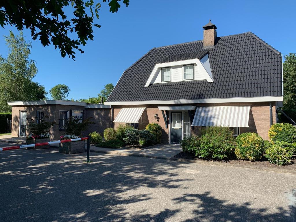 una casa con techo negro y entrada en de Goede Ree Huisje 1 en 2 - No Companies, en Goedereede