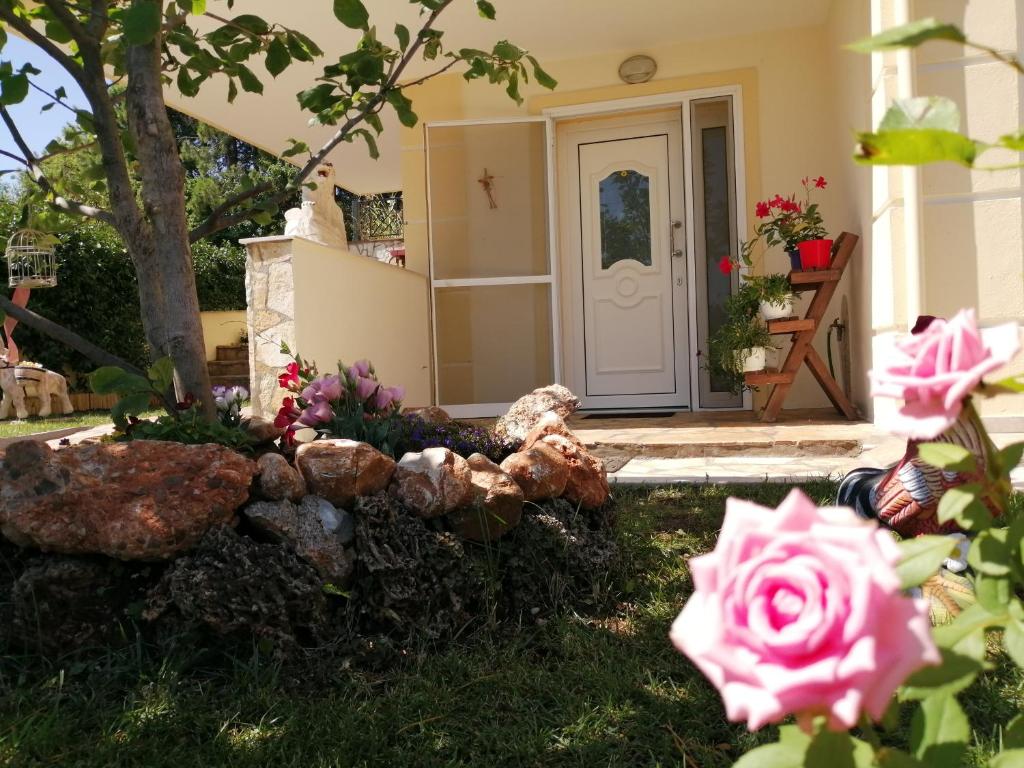 a front door of a house with pink roses at Swan's garden olympus luxury apartment in Litochoro