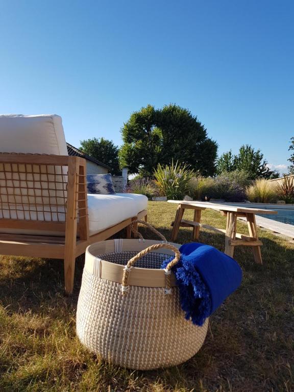 a basket sitting next to a bench and a table at Les Hauts De Chalonne in Le Gond-Pontouvre