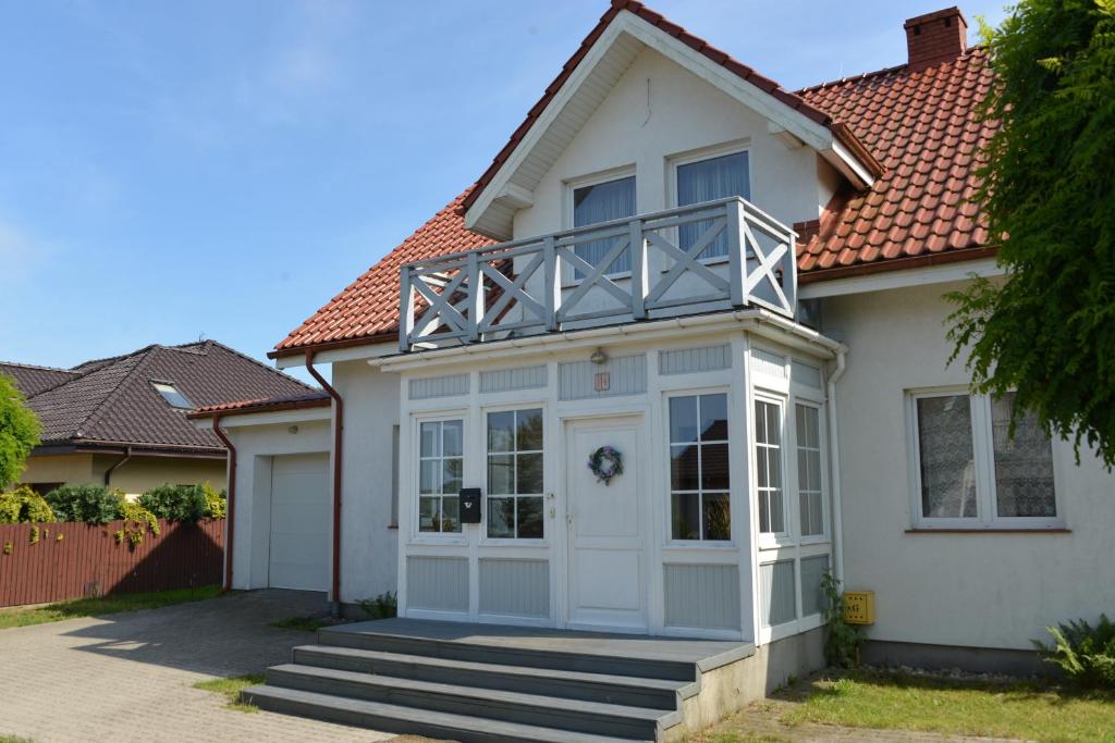 a white house with a balcony on top of it at Dom Nadmorski "Casa Azul" Gdynia Kosakowo in Mechelinki