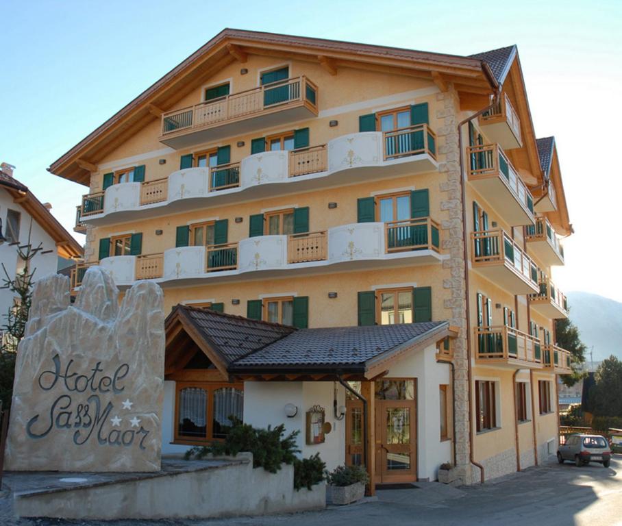 ein großes Gebäude mit einem Schild davor in der Unterkunft Hotel Sass Maor in Fiera di Primiero