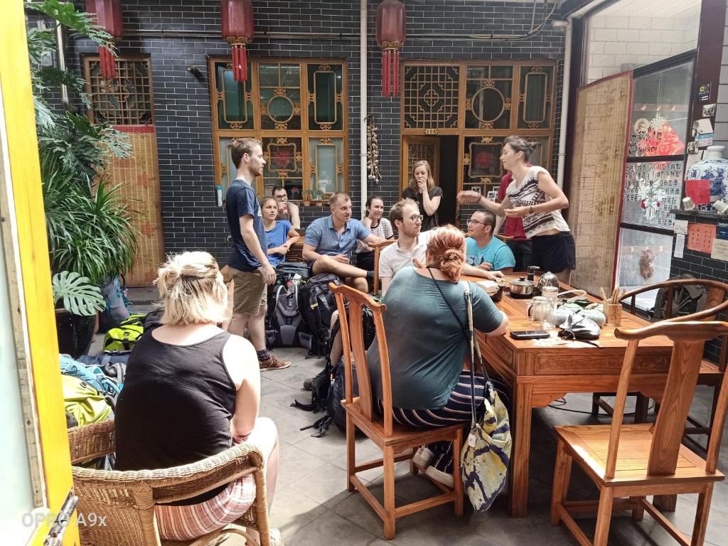 a group of people sitting at a table in a restaurant at Pingyao Jiaxin Guesthouse in Pingyao