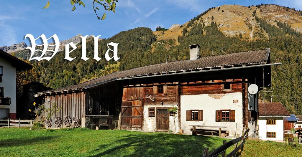 an old barn with a mountain in the background at Ferienhaus Wella in Holzgau