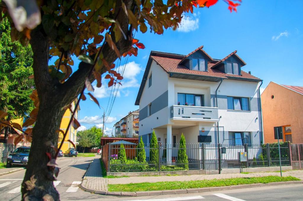 a white house with a red roof at Vila Roza in Sighetu Marmaţiei