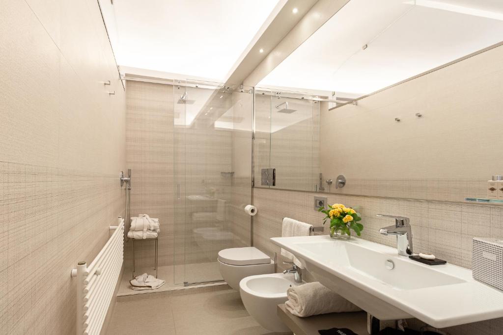 
a bathroom with a toilet, sink, and mirror at Harry's Bar Trevi Hotel & Restaurant in Rome
