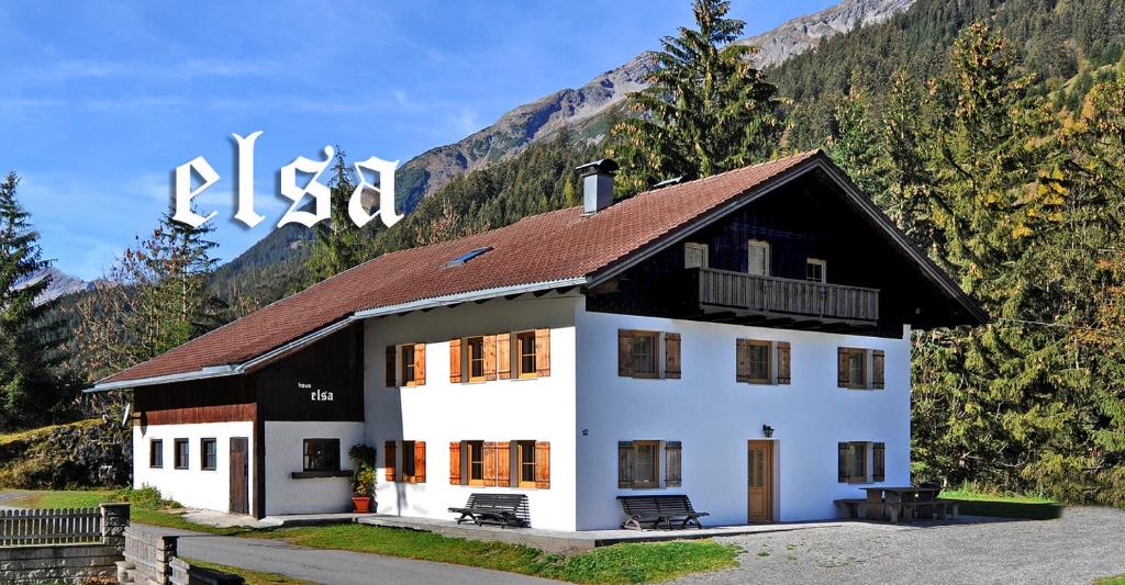 ein großes weißes Haus mit braunem Dach in der Unterkunft Haus Elsa in Holzgau